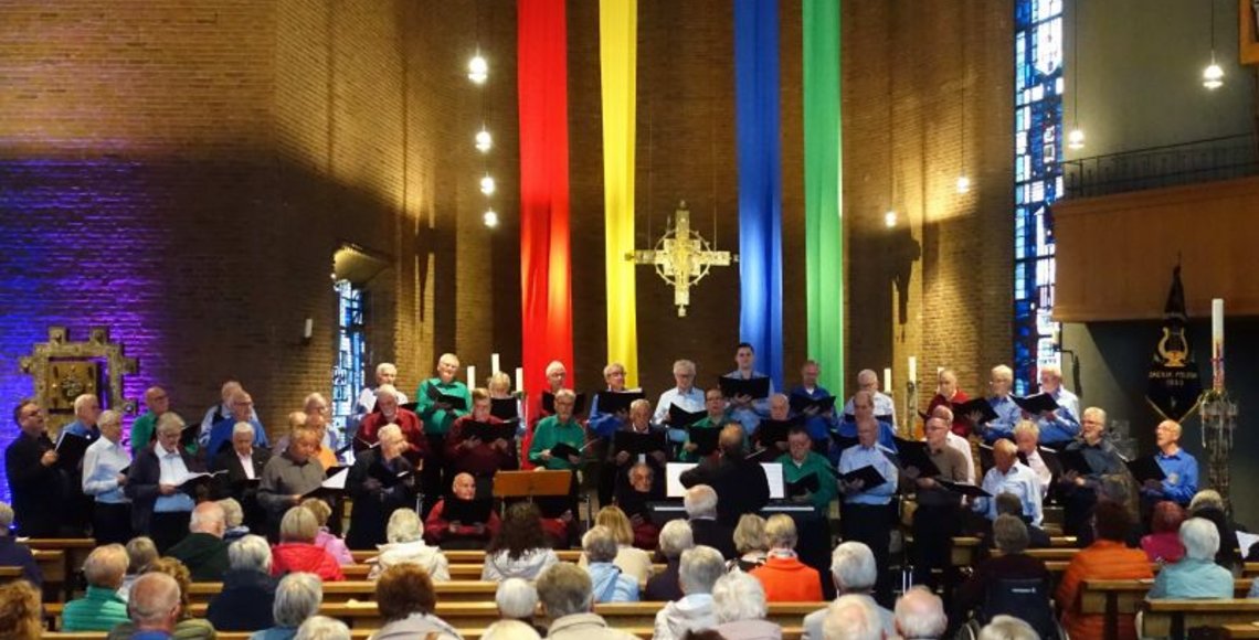 Das Foto zeigt den Männergesangverein beim Gedenkkonzert in der bunt geschmückten Kirche.