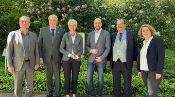 Das Gruppenfoto zeigt die Kooperationspartner zu Anfang der Gedenkveranstaltung - (v.l.) Jürgen Pohl, Georg Möllers (beide Verein für Orts- und Heimatkunde), Dorothee Feller (NRW-Ministerin), Dr. Ansgar Kortenjann (Leiter der Volkshochschule), Dr. Sebastian Sanders (Sozial-Dezernent und Ortsverbandsvorsitzender des Volksbundes Deutsche Kriegsgräberfürsorge e.V.) sowie Nina Kliemke (Bildungsreferentin des Volksbundes Deutsche Kriegsgräberfürsorge e.V.).
